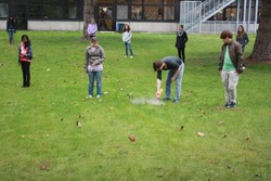 Schüler karkieren die Grünfläche vor dem Entferner der Grasnabe